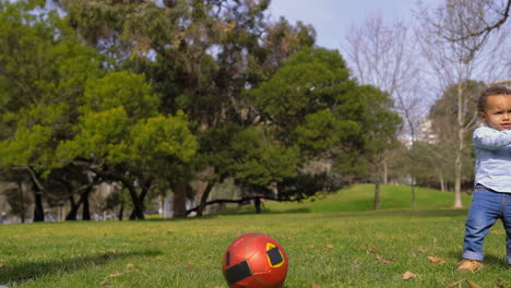 Boy-practicing-with-soccer-ball,-playing-pass-to-father